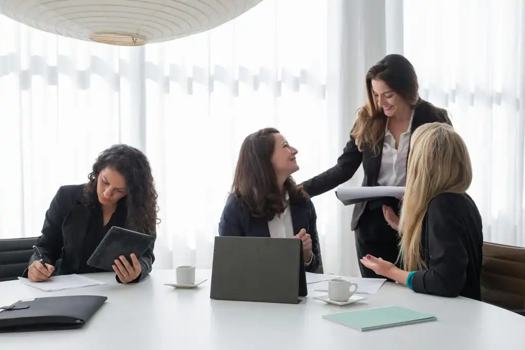 Vier Damen diskutieren freundlich im Konflikte und Beschwerden Seminar.