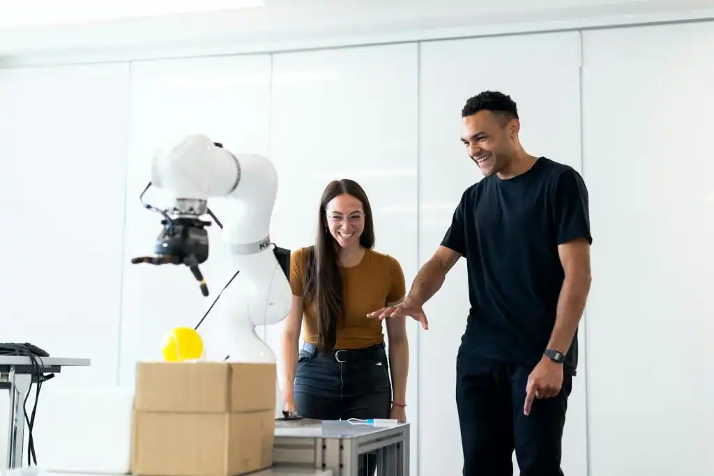 Ein Trainer der KI Automatisierung Seminare zeigt einer Teilnehmerin ein Beispiel für Automatisierungsprozesse