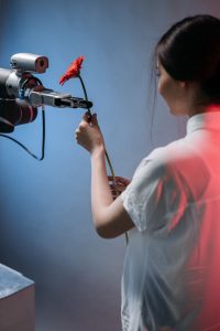 Eine Frau bekommt von einen Roboter und KI-Agenten eine Blume überreicht