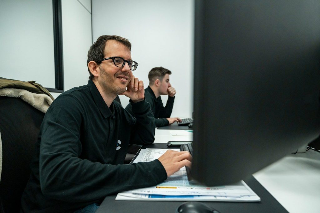 Zwei Teilnehmer arbeiten in den AutoCAD AutoLISP Schulungen und einer lächelt zufrieden